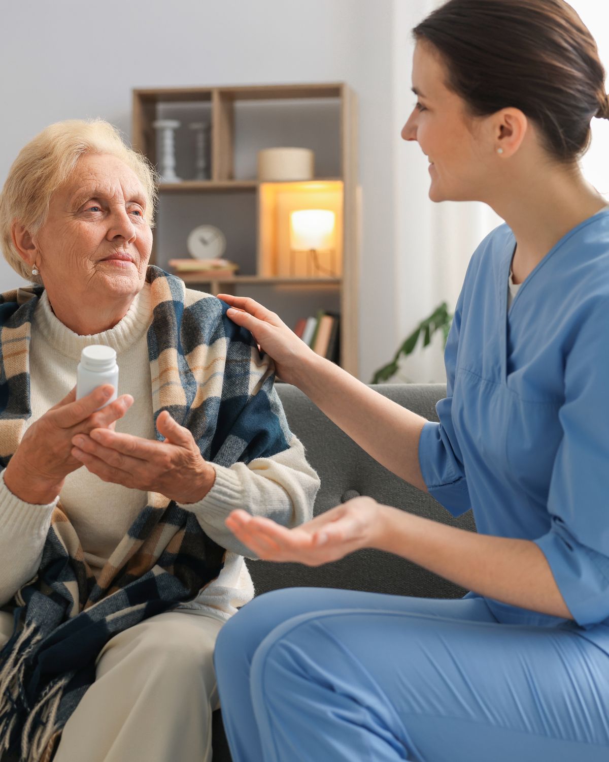 A Jaama caregiver helping an elderly client manage her daily medication at home